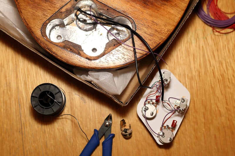 Guitar electronic with tools on a wooden desk