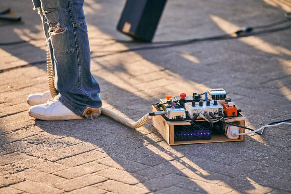 Effects pedal box for electric guitar on floor at outdoor rock party