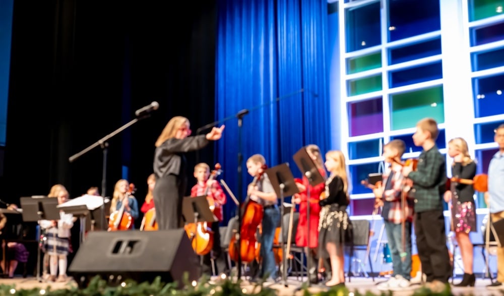 elementary musical concert with students lined up on stage to play music instruments